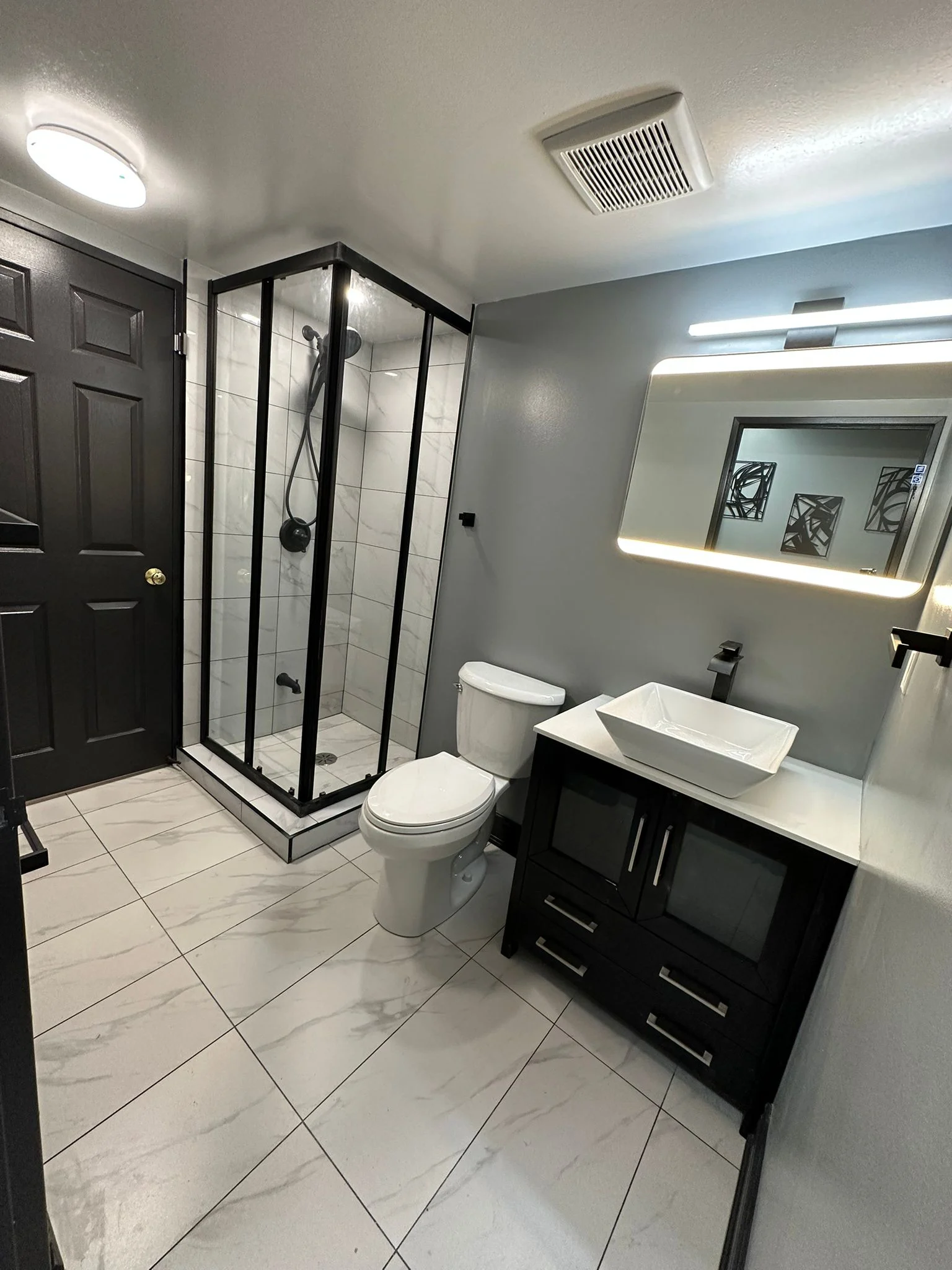 Bathroom with dark vanity and tiled floor